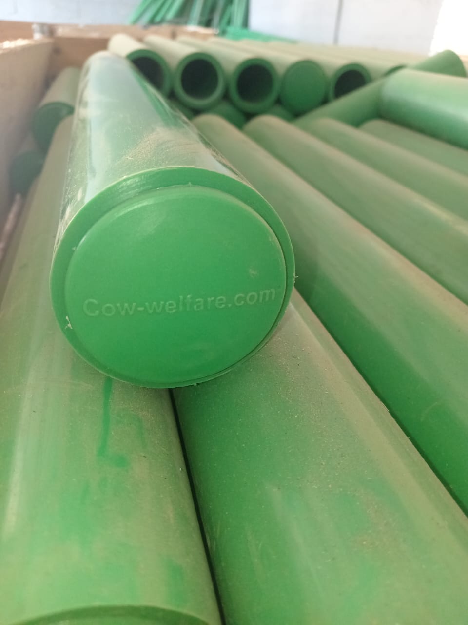 Green cow-comfort components stacked in warehouse